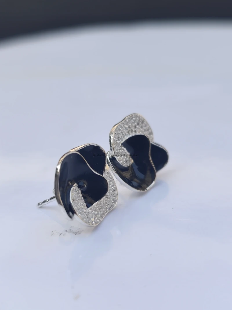 Navy enamel swirl stud earrings, close-up view